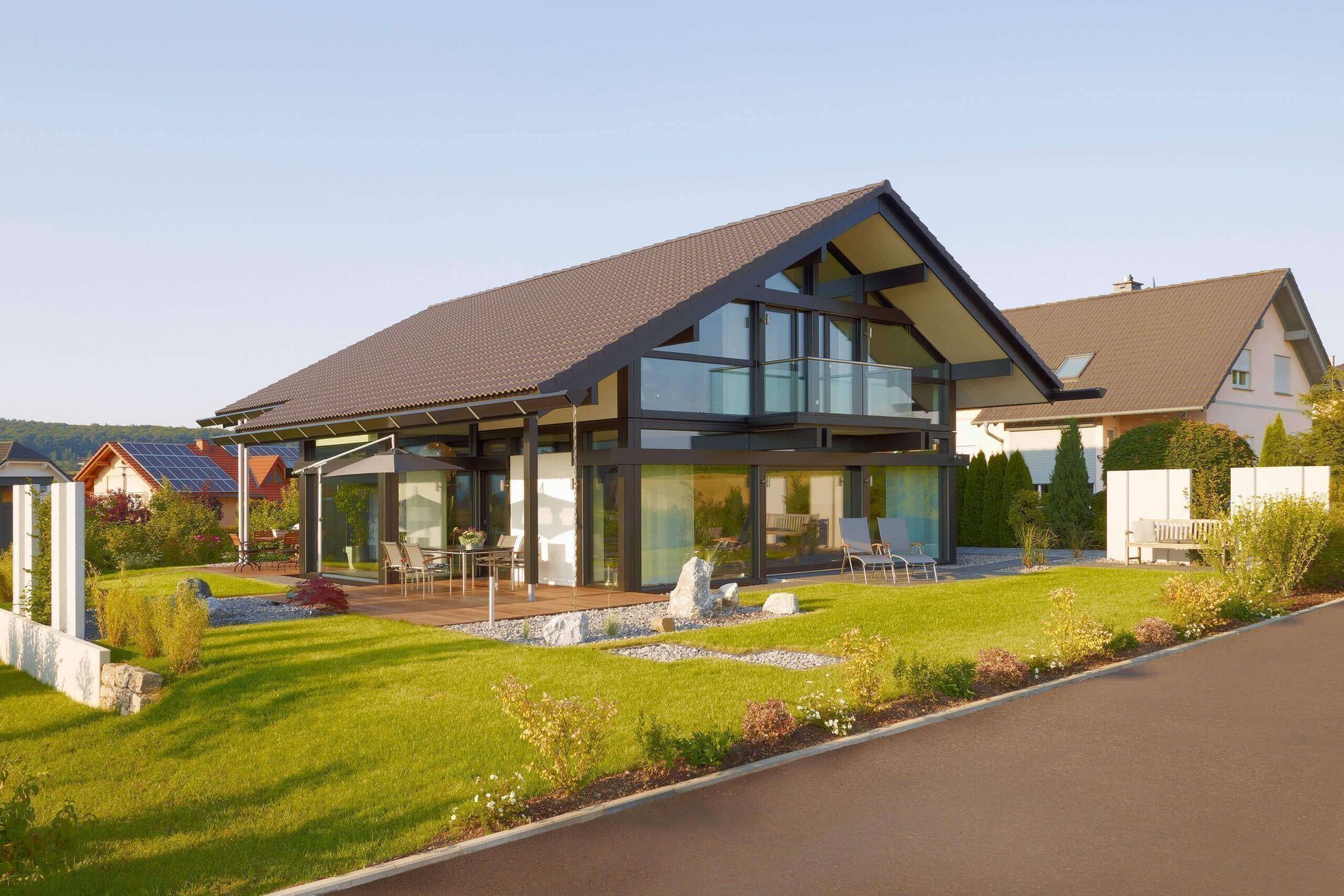 Architektenhaus in grüner Umgebung mit Sitzgelegenheiten und Holzterrasse