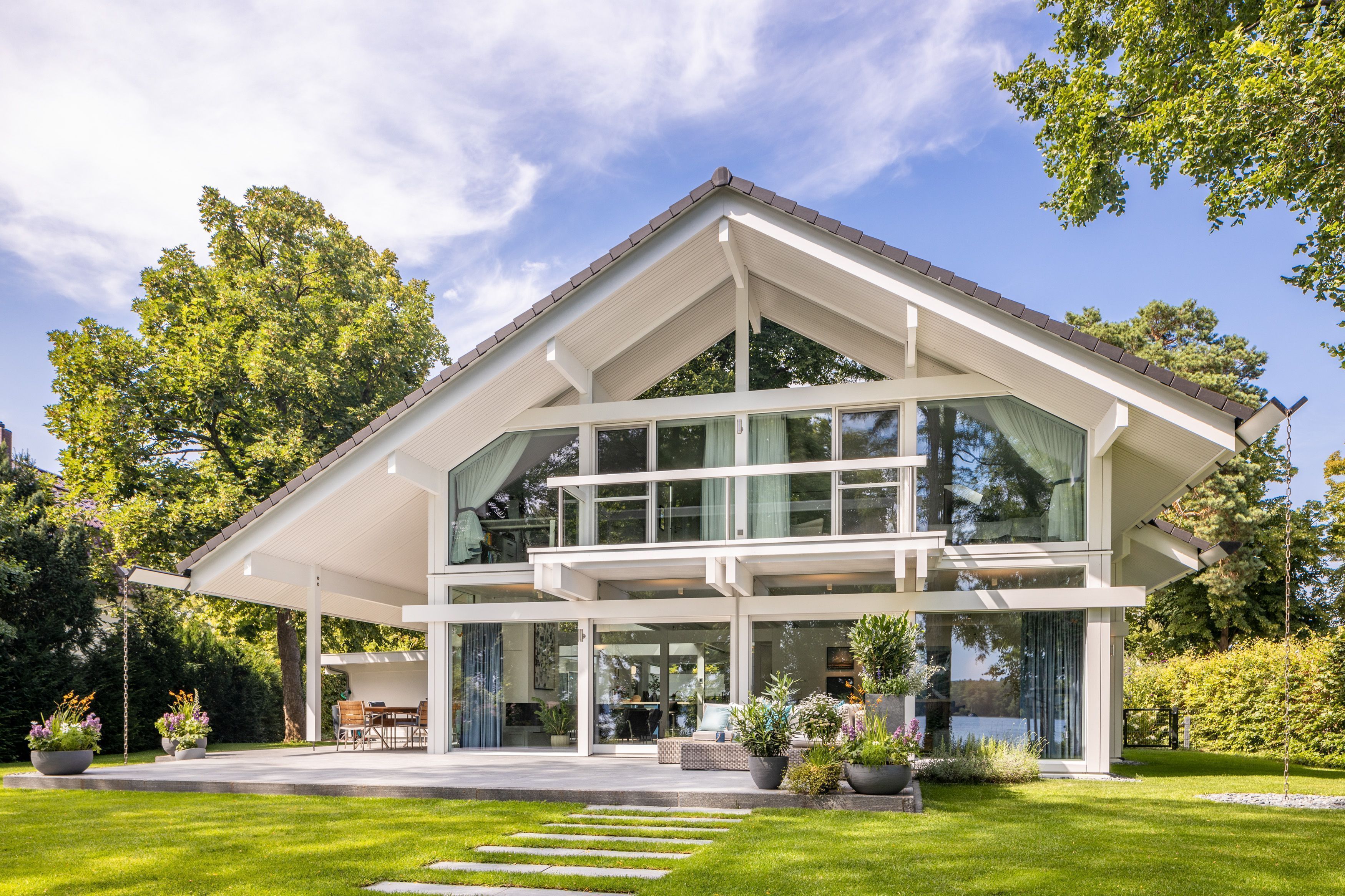 Herrliches HUF Architektenhaus am Wasser Modernes HUF Haus mit großen Fenstern und grünem Garten