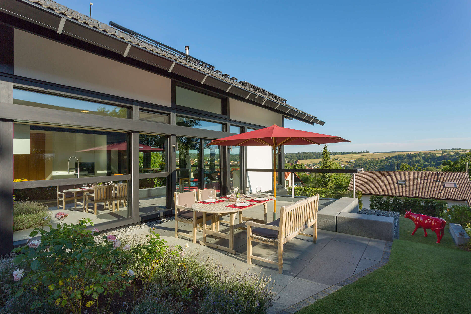 Ein HUF Haus mit Glas-Architektur und Terrasse im Freien.