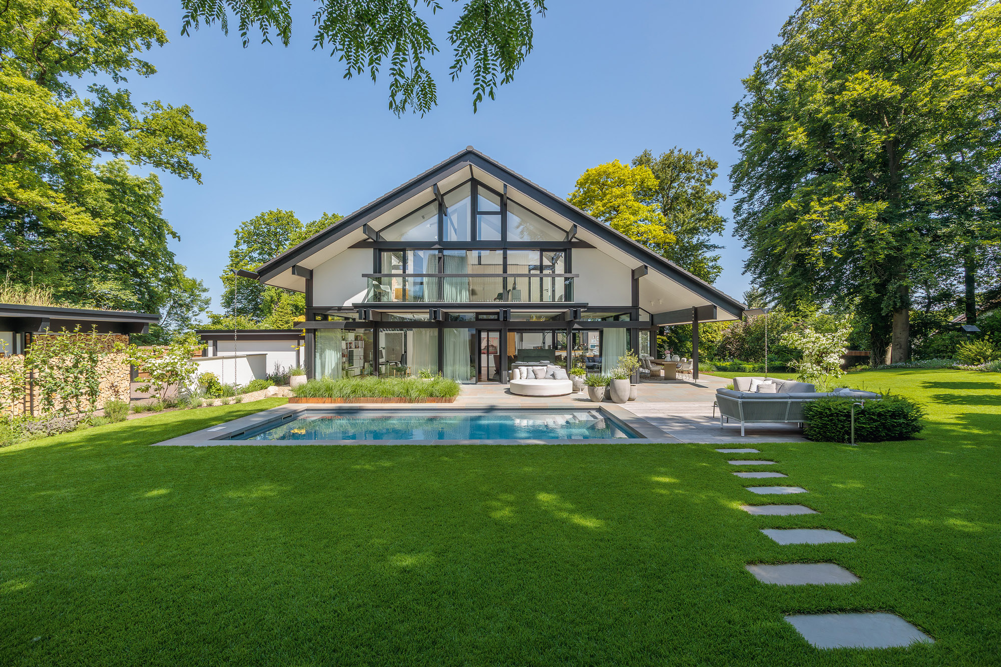 Modernes HUF Haus mit Fachwerk-Glas-Architektur Architektenhaus mit Garten und Pool, zeitloses Design.