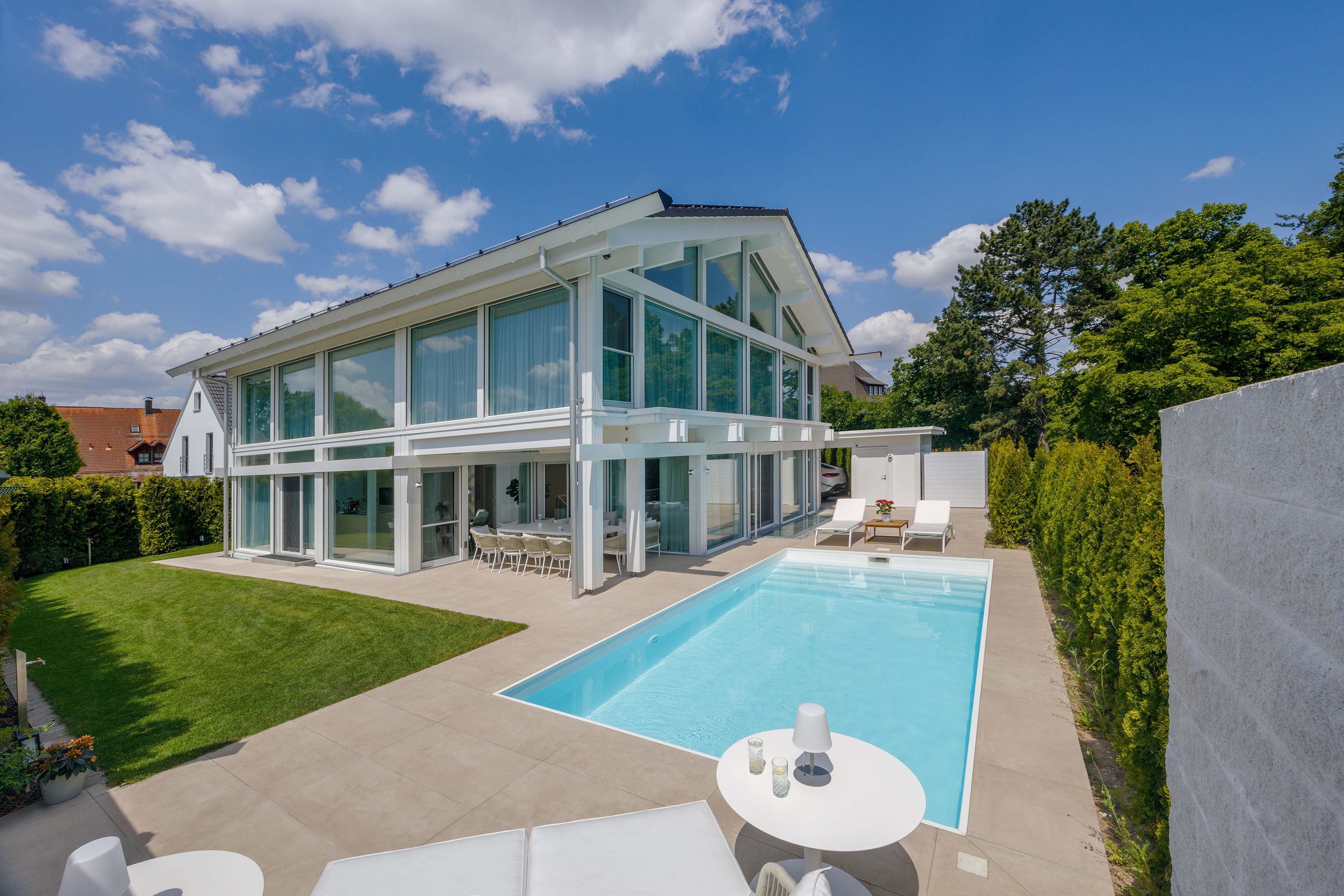 Modernes HUF Haus mit Pool und Garten Außenansicht eines modernen HUF Hauses mit Schwimmbad und grünem Garten