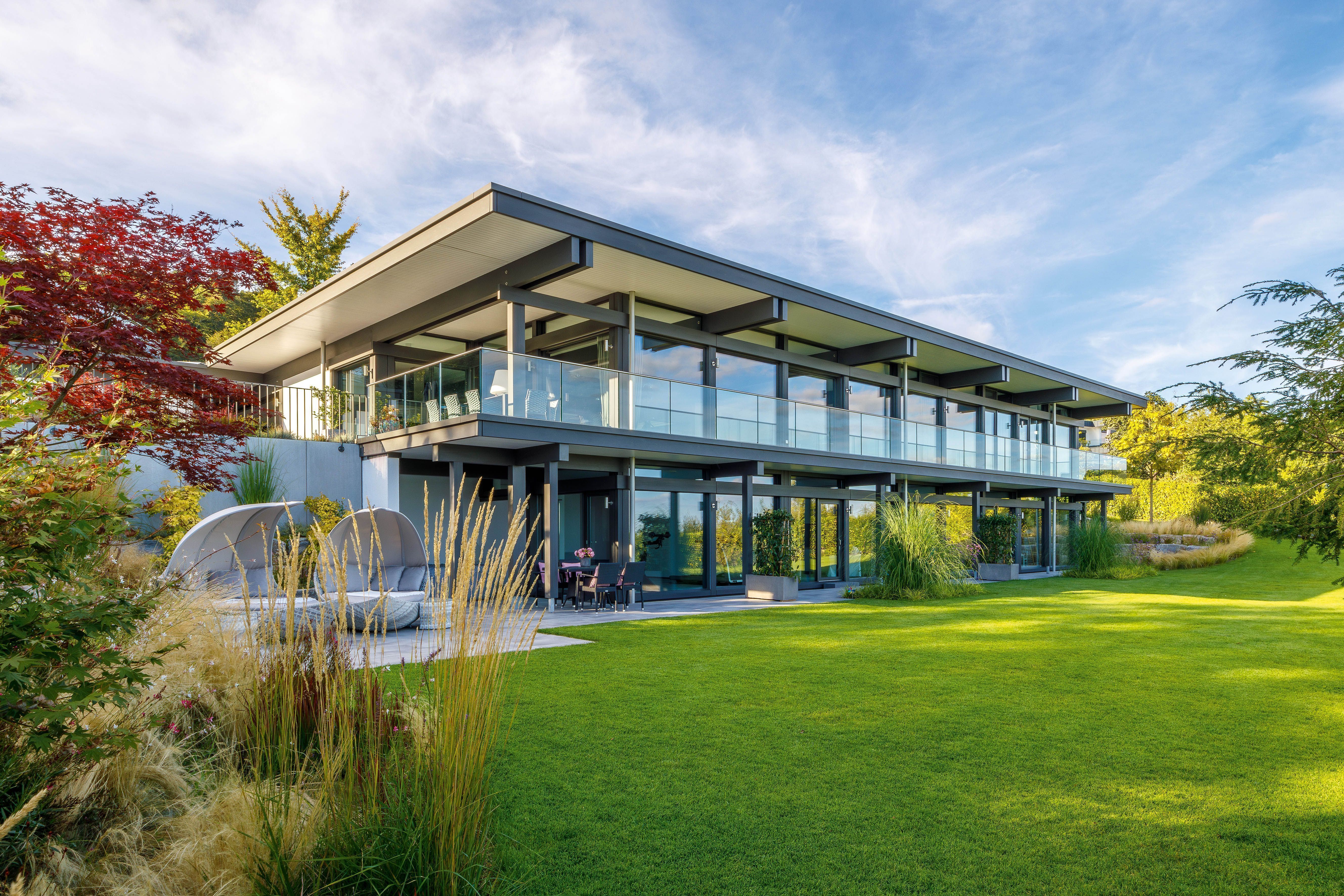 Maximale Transparenz im HUF HAUS mit Flachdach Modernes HUF HAUS mit großflächigen Fenstern und Flachdach.