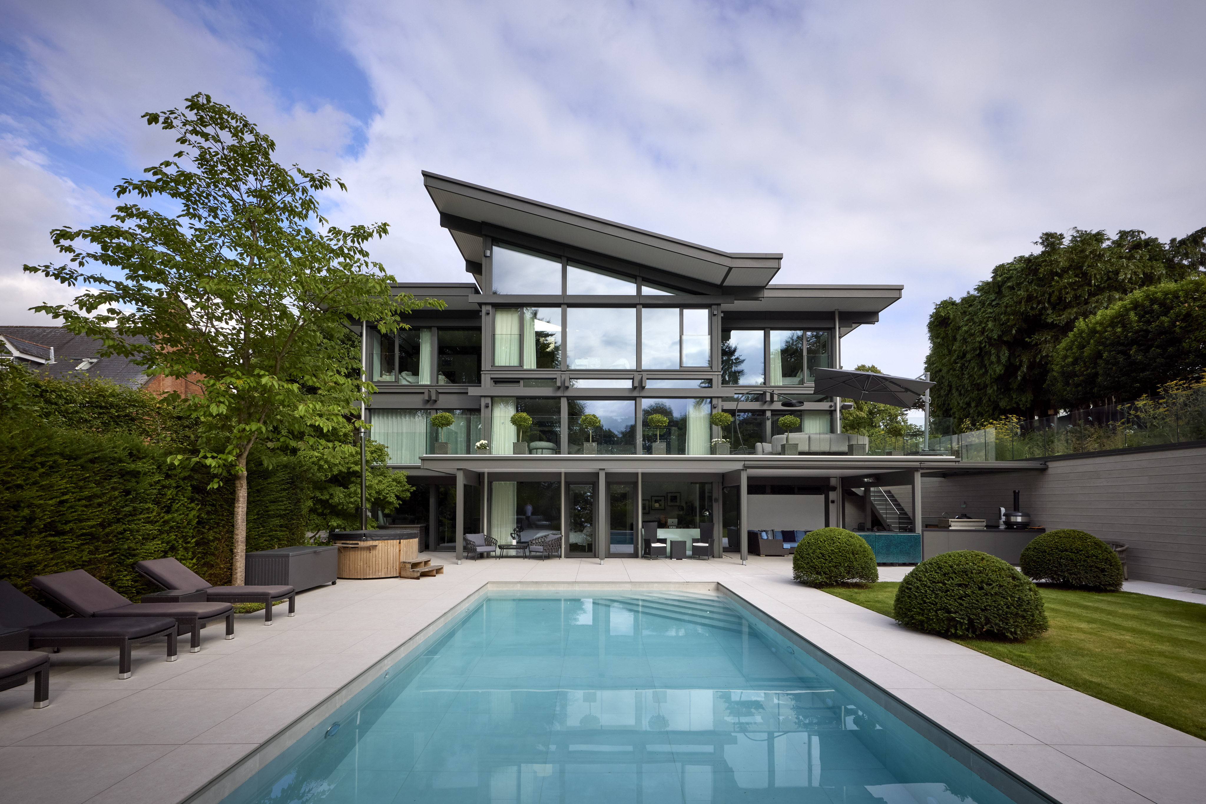 Modernes HUF Haus mit Pool und Gartenlandschaft Elegantes HUF Haus mit gläserner Fassade und Swimmingpool