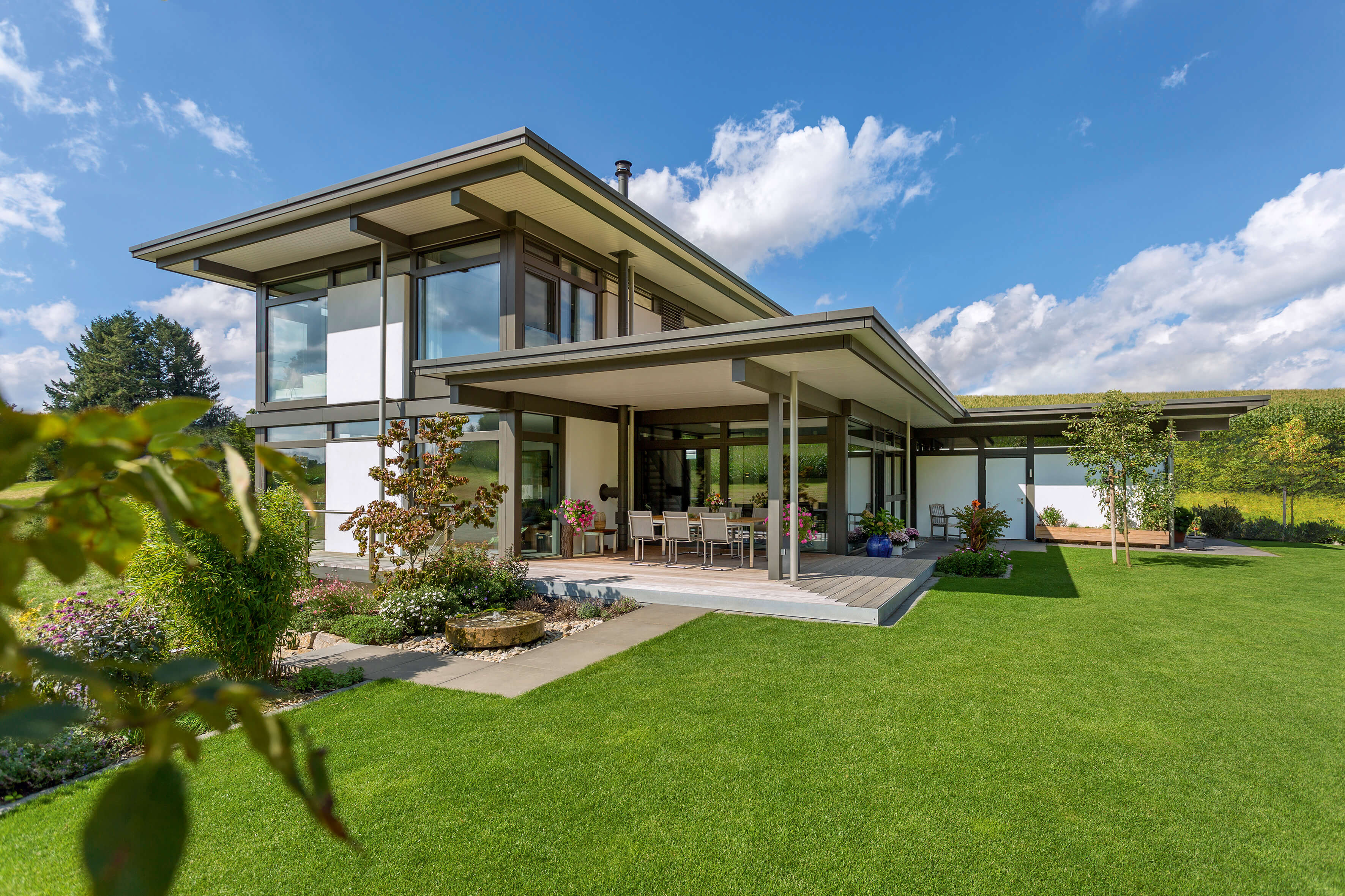 Stilvolles modernes Fachwerkhaus im Grünen Helles modernes Fachwerkhaus mit großem Garten und blauen Himmel