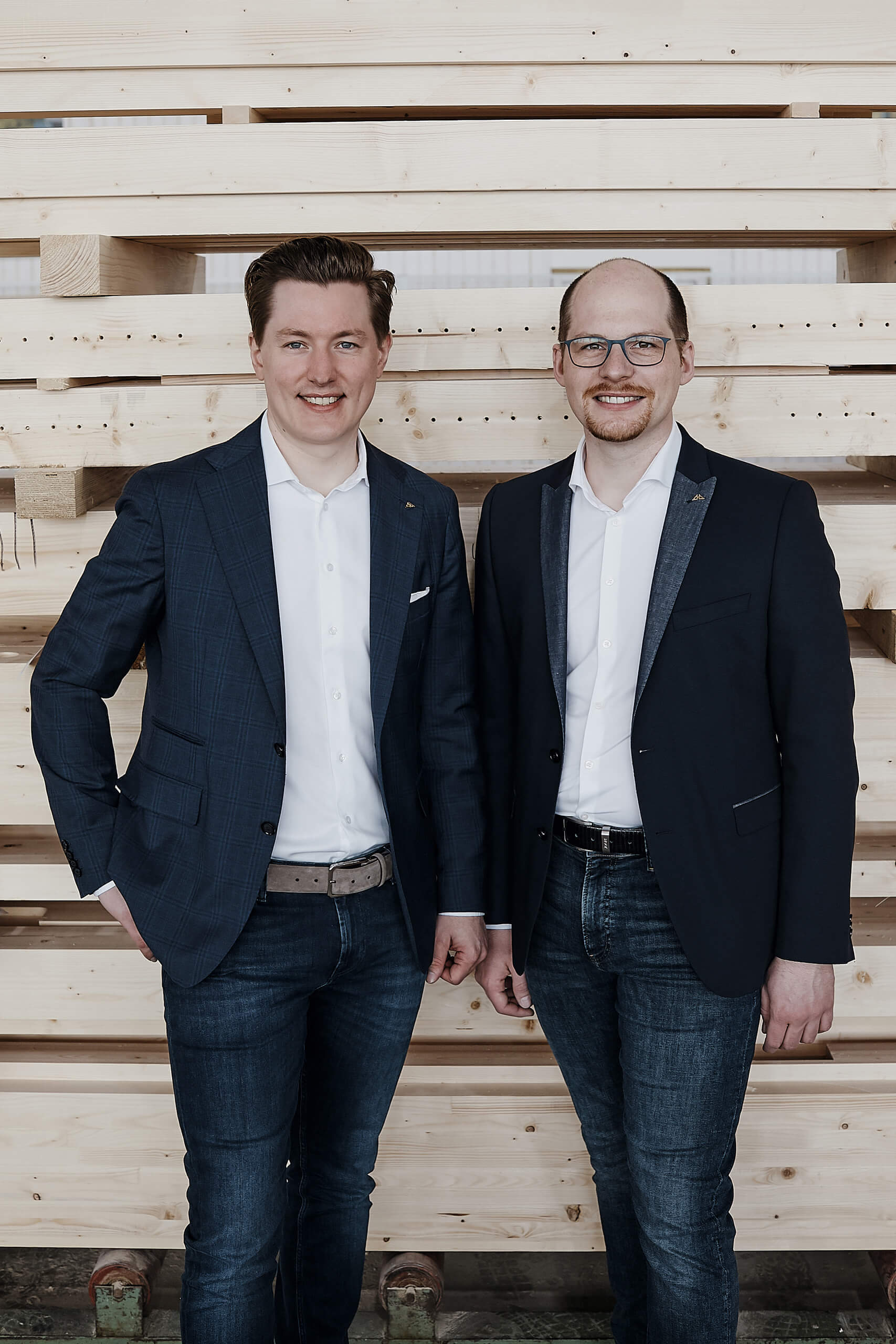 Zwei Männer in Anzügen vor einer Holzwand Christian und Benedikt Huf