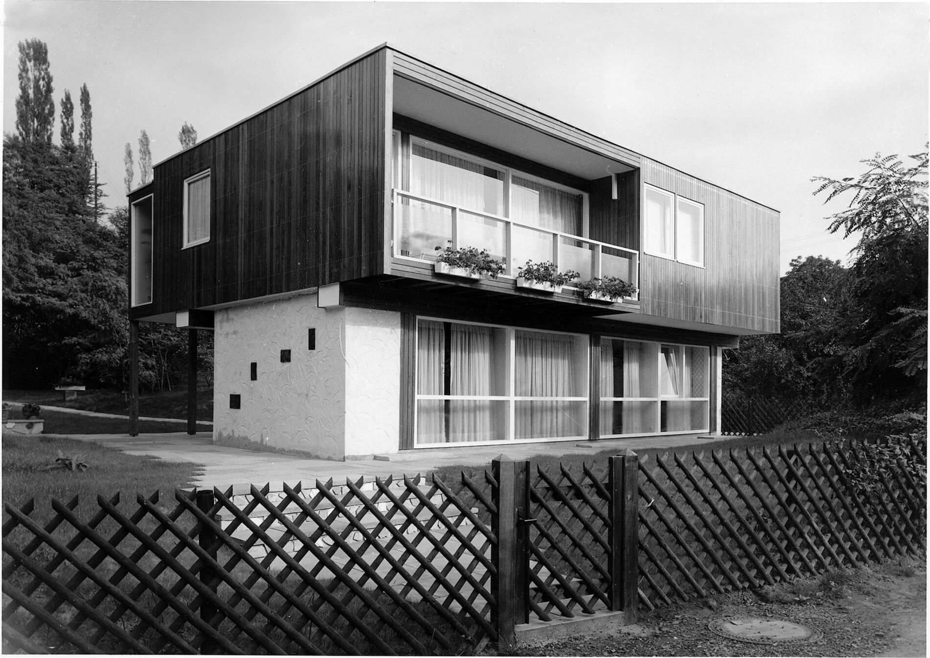 Modernes Haus mit Balkon und Holzelementen Haus mit moderner Architektur, Holzverkleidung und Balkon