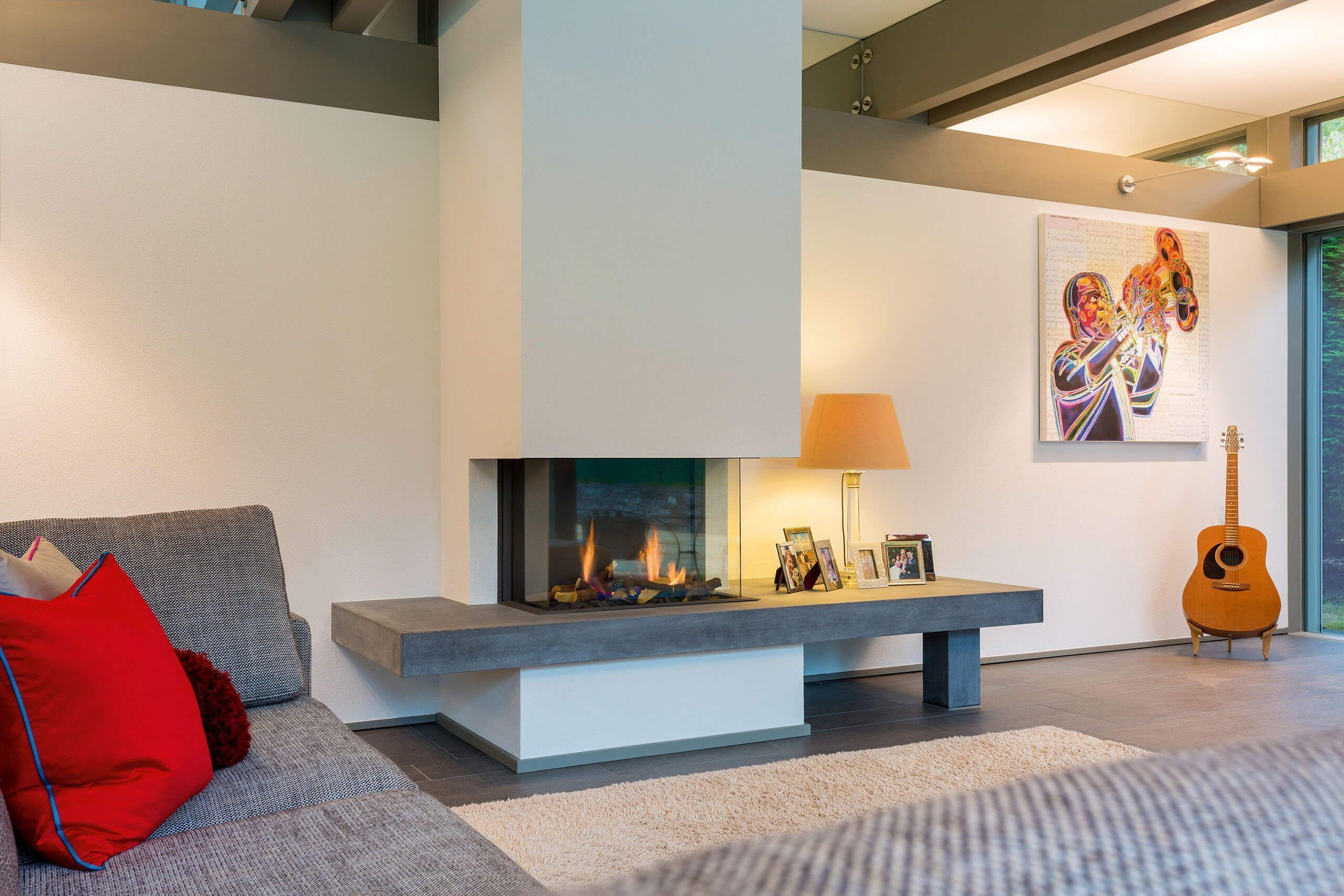 Modern living room with fireplace and guitar Cozy interior featuring a fireplace, soft seating, and artwork