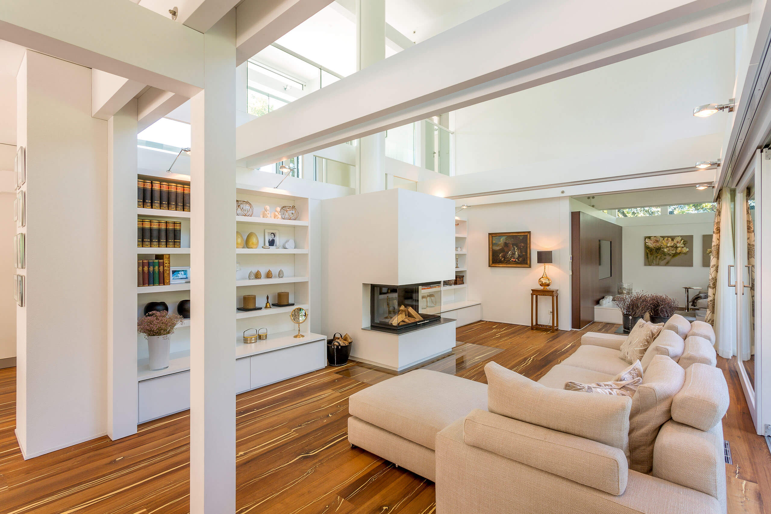 Modernes Wohnzimmer mit Bücherregal und Kunstwerken Helles Wohnzimmer mit offener Architektur und stilvollem Mobiliar