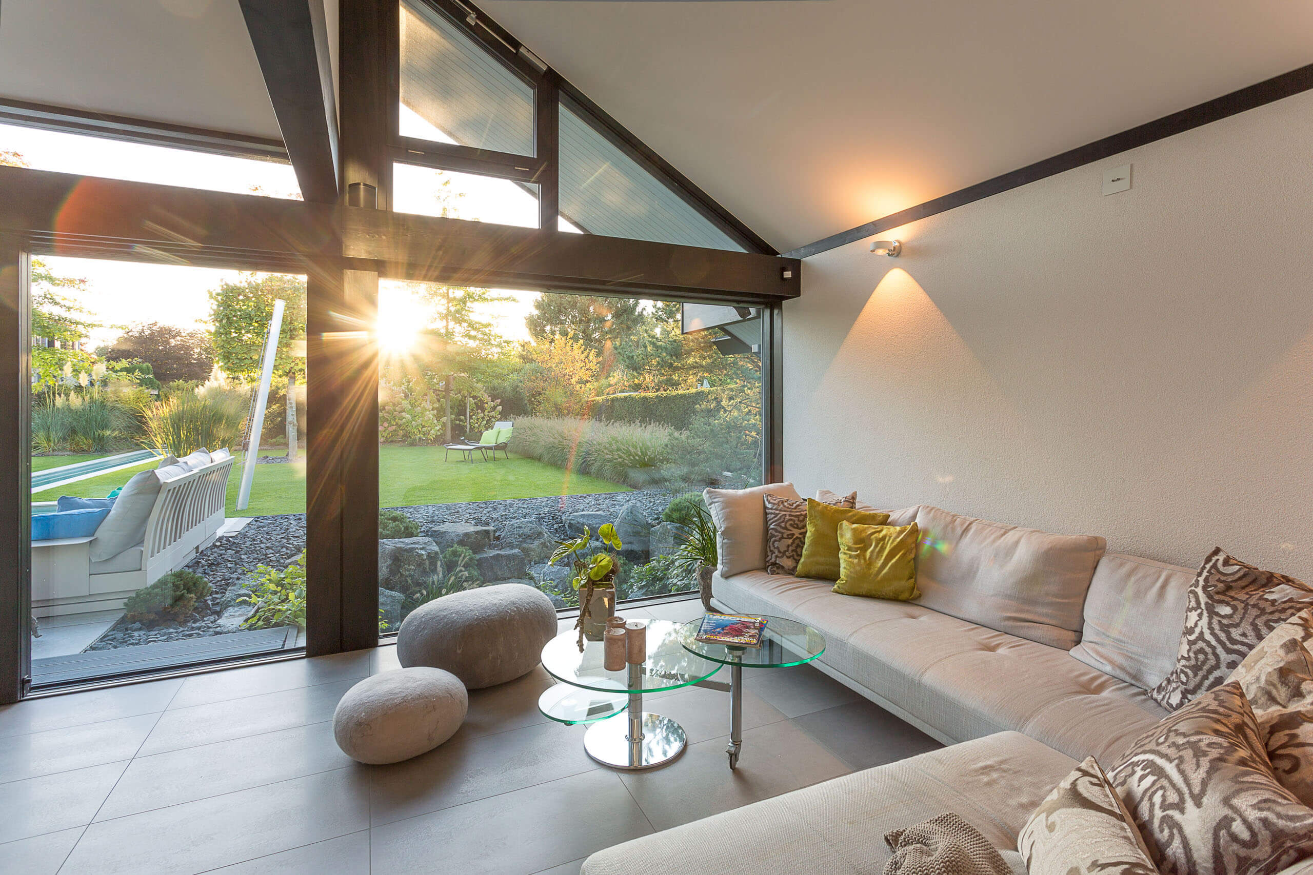 Moderne Wohnlandschaft mit Gartenblick bei Sonnenuntergang Gemütlicher Wohnraum mit heller Einrichtung und Blick auf den Garten