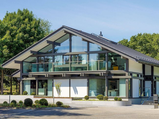 Stilvolles, modernes Haus mit Glasfront und angrenzender Landschaft