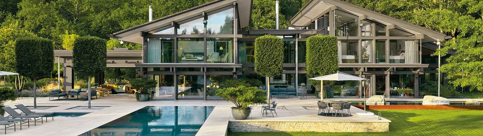 Luxuriöse Architektur mit Glasfassade und gepflegtem Garten