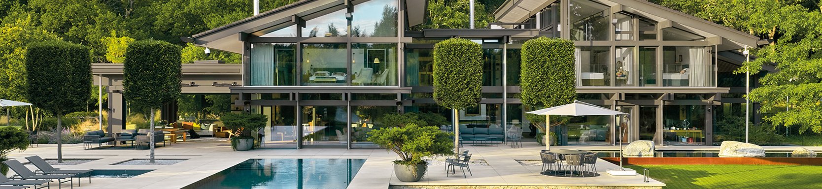 Luxuriöse Architektur mit Glasfassade und gepflegtem Garten