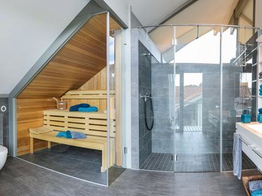 Helles Badezimmer mit Sauna, Dusche und modernen Armaturen