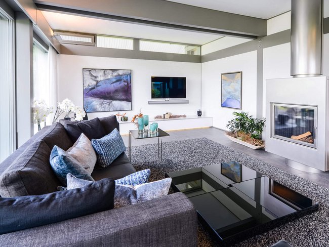Elegantes Wohnzimmer mit Sofa, Kamin und Kunstwerken an der Wand
