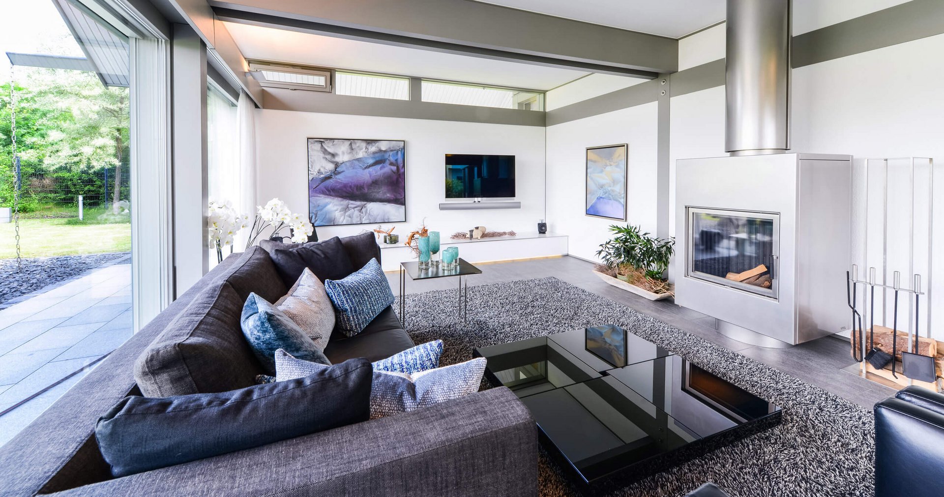 Elegantes Wohnzimmer mit Sofa, Kamin und Kunstwerken an der Wand