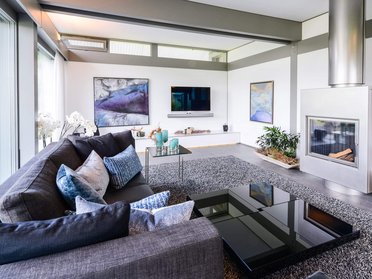 Elegantes Wohnzimmer mit Sofa, Kamin und Kunstwerken an der Wand