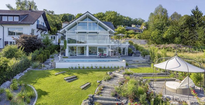 Luftaufnahme einer modernen Villa mit gepflegtem Garten und Swimmingpool