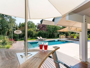 Moderne Terrasse mit Blick auf den Pool in einem schönen Garten
