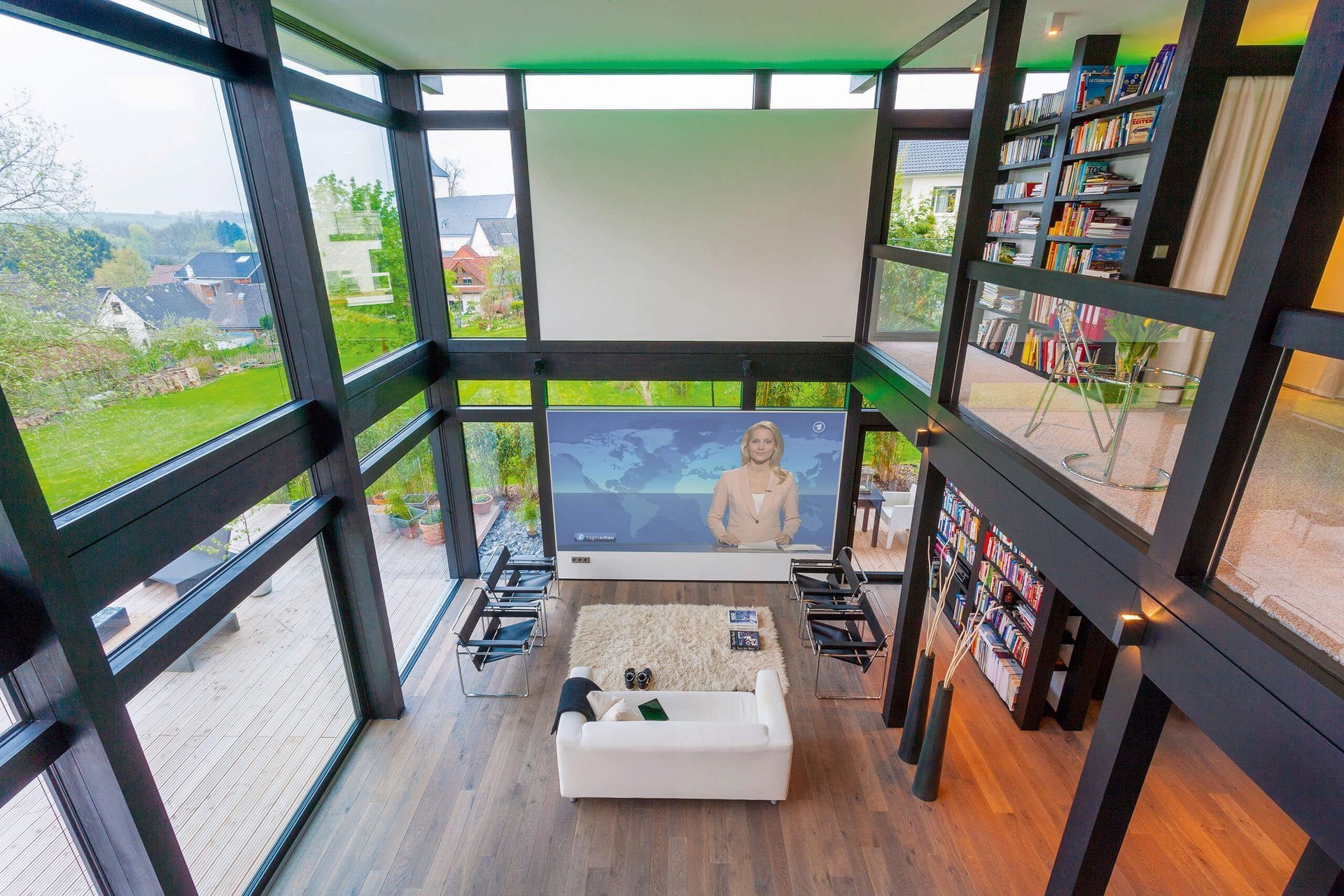 Lichtdurchflutetes Wohnzimmer mit Aussicht und Fernseher