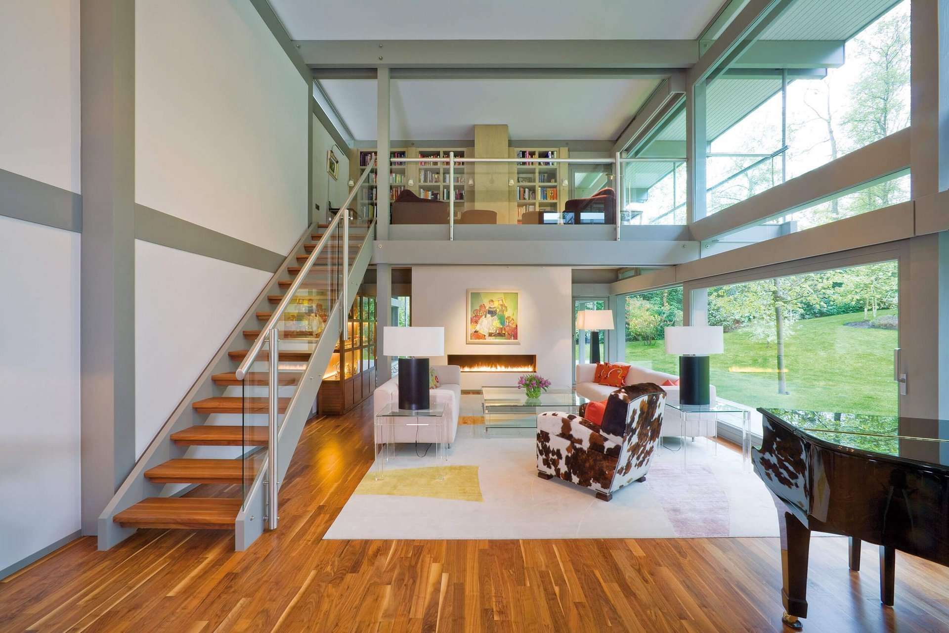 Modernes Wohnzimmer mit offener Treppe und großen Fenstern Helles, modernes Wohnzimmer mit Holzfußboden, Treppe und Fensterblick