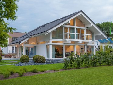 Stylisches modernes Haus mit großen Fenstern und gepflegtem Grün