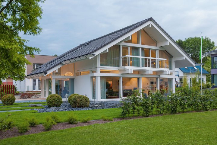 Stylisches modernes Haus mit großen Fenstern und gepflegtem Grün