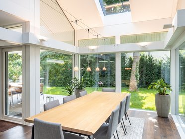 Innenansicht eines Architektenhauses mit Essbereich und großen Fenstern