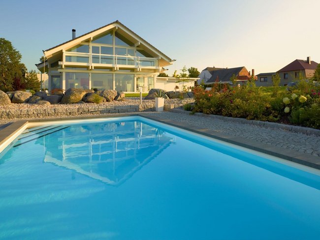 Fachwerkhaus HUF HAUS ART 4 mit Pool Moderne Architektur eines Fachwerkhauses mit Swimmingpool und Garten