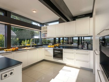 Moderne Küche im HUF Haus mit Offenheit und Licht Küche eines HUF Hauses mit Glasfenstern und zeitlosem Design