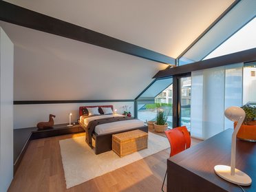 Ein stilvolles Schlafzimmer mit Holzfußboden und großen Fenstern