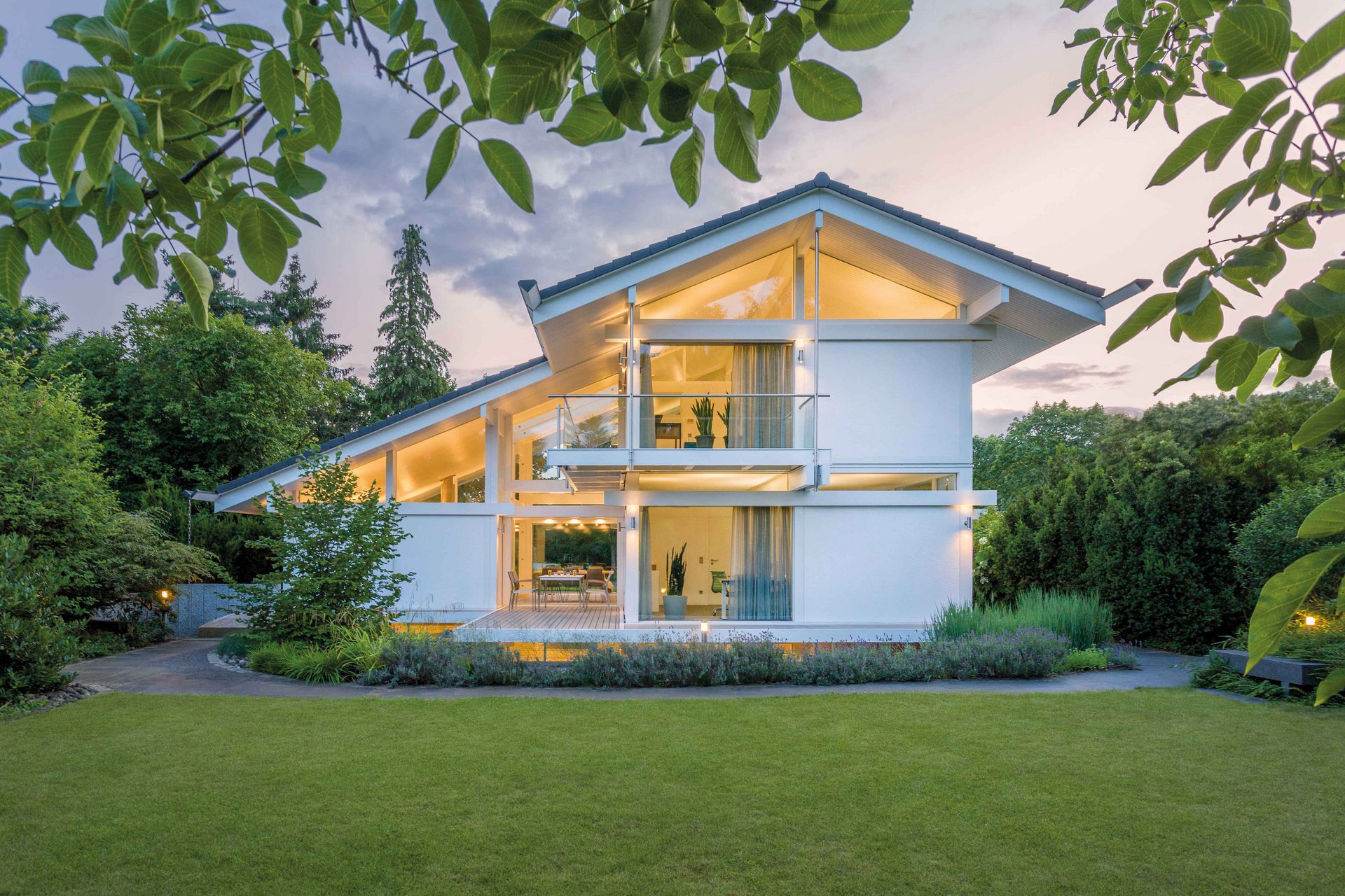 Jubiläumskalender 110 Jahre HUF HAUS Moderne Architektur eines HUF HAUS im Grünen bei Sonnenuntergang