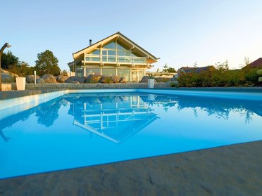 Fachwerkhaus HUF HAUS ART 4 mit Pool im Blick Moderne Architektur mit Schwimmbecken und Naturumgebung