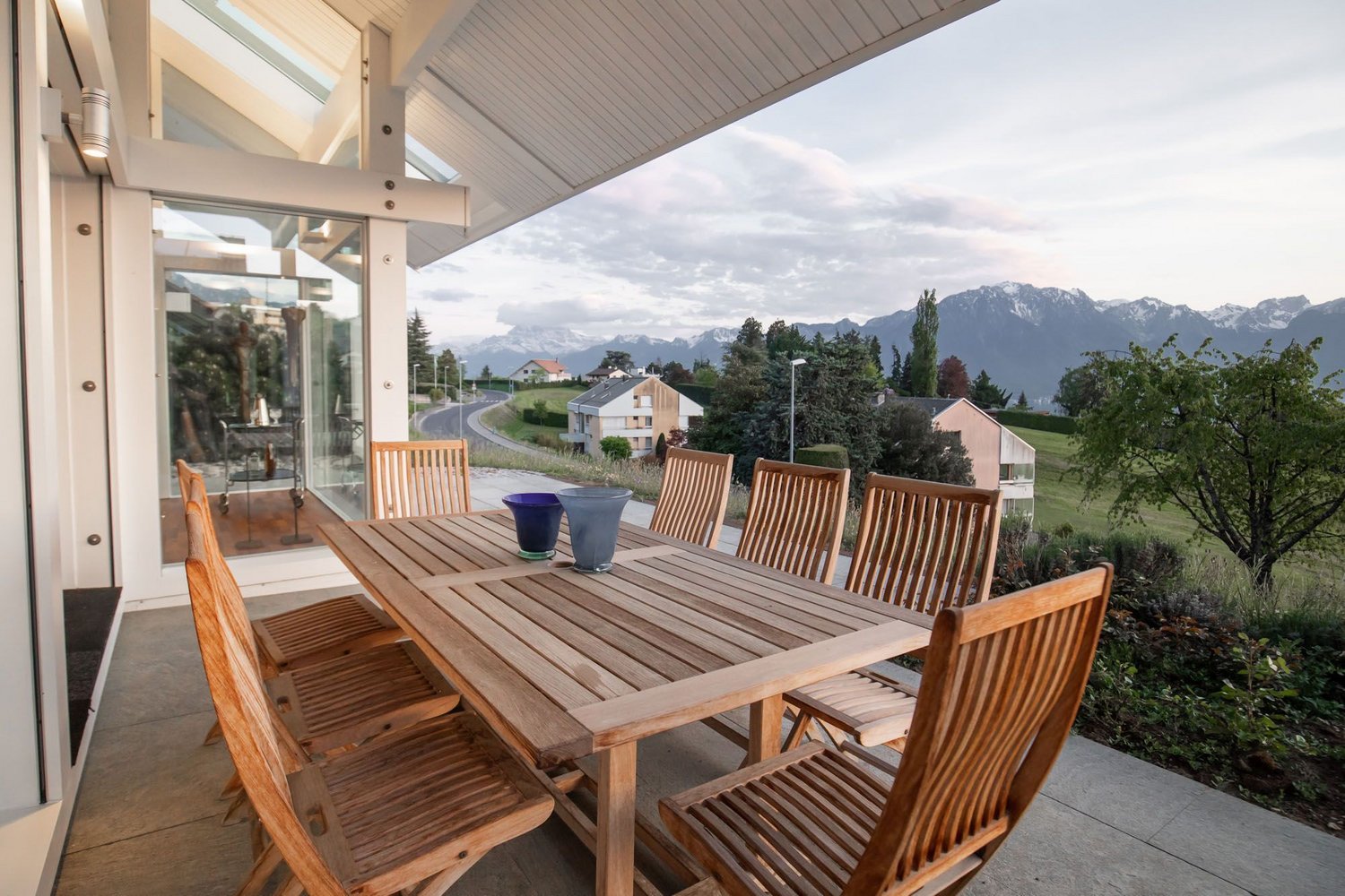 Holztisch und Stühle auf einer Terrasse mit Bergblick und ruhiger Umgebung