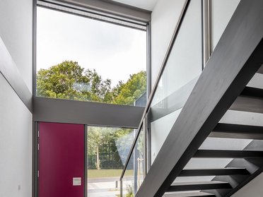 Innenansicht eines modernen Fertighauses mit Treppe und großer Fensterfront