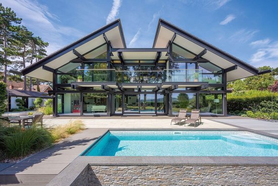 Haus mit bodentiefen Fenstern und Pool in natürlicher Umgebung