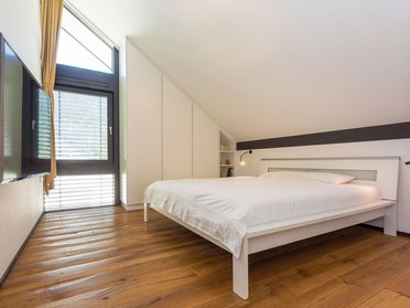 Modernes Schlafzimmer im Architektenhaus mit Holzfußboden und TV
