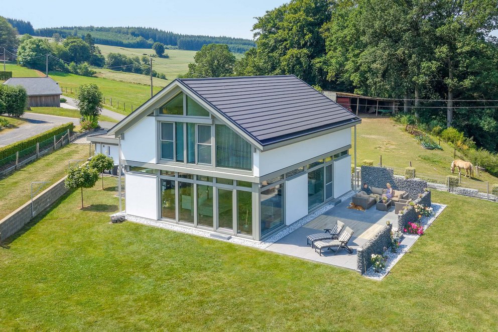 Luftaufnahme eines modernen Hauses mit schönem Garten und umliegender Landschaft