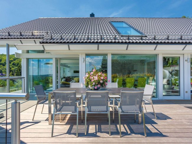 Moderne Terrasse mit Esstisch, Blick auf die Landschaft und viel Licht