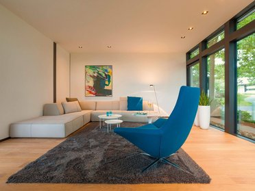 Lichtdurchflutetes Wohnzimmer mit Sofa und blauer Akzentfarbe