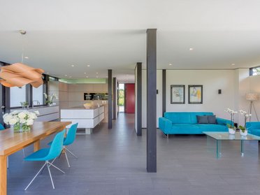 HUF house modum 810 17 Heller Wohnraum mit blauen Möbeln und moderner Einrichtung