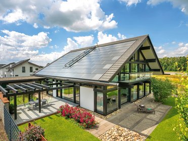 Ansicht eines modernen Hauses mit Pflanzen und Solarpanelen