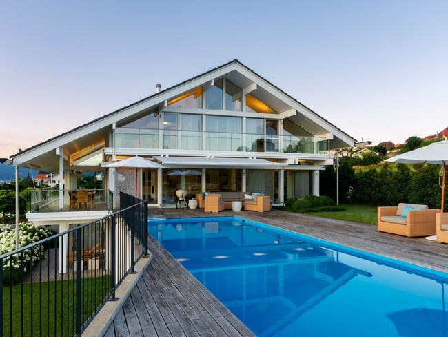 Ein stilvolles Haus mit Glaselementen und einem Swimmingpool im Garten