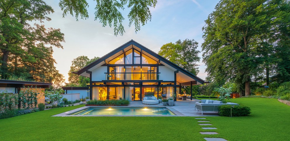 HUF Haus mit großer Glasfassade und grüner Gartenlandschaft