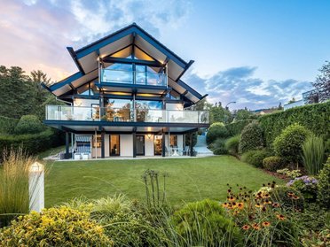 Moderne Wohnraumerweiterung eines HUF HAUS mit Gartenansicht