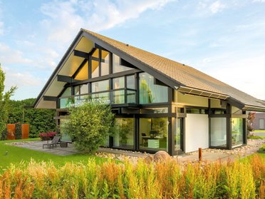 Elegantes modernes Haus mit großen Fenstern und gepflegtem Garten