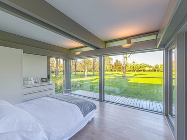 Stilvoller HUF Anbau mit Blick ins Grüne Moderne Schlafräume im HUF Anbau mit großzügigen Fensterflächen