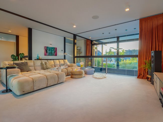 Modernes Designhaus mit Flachdach und stilvollem Interieur Geräumiges Wohnzimmer mit eleganter Möbelanordnung und Blick ins Freie
