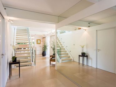 Helles Foyer mit Treppe und Blick auf offenen Essbereich und Küche