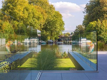 Moderne Architektur mit Glas und Garten, umgeben von Natur