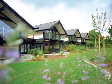 Moderne Wohnhäuser mit Gartenanlage Ansicht von modernen Häusern mit Glasfronten und Garten
